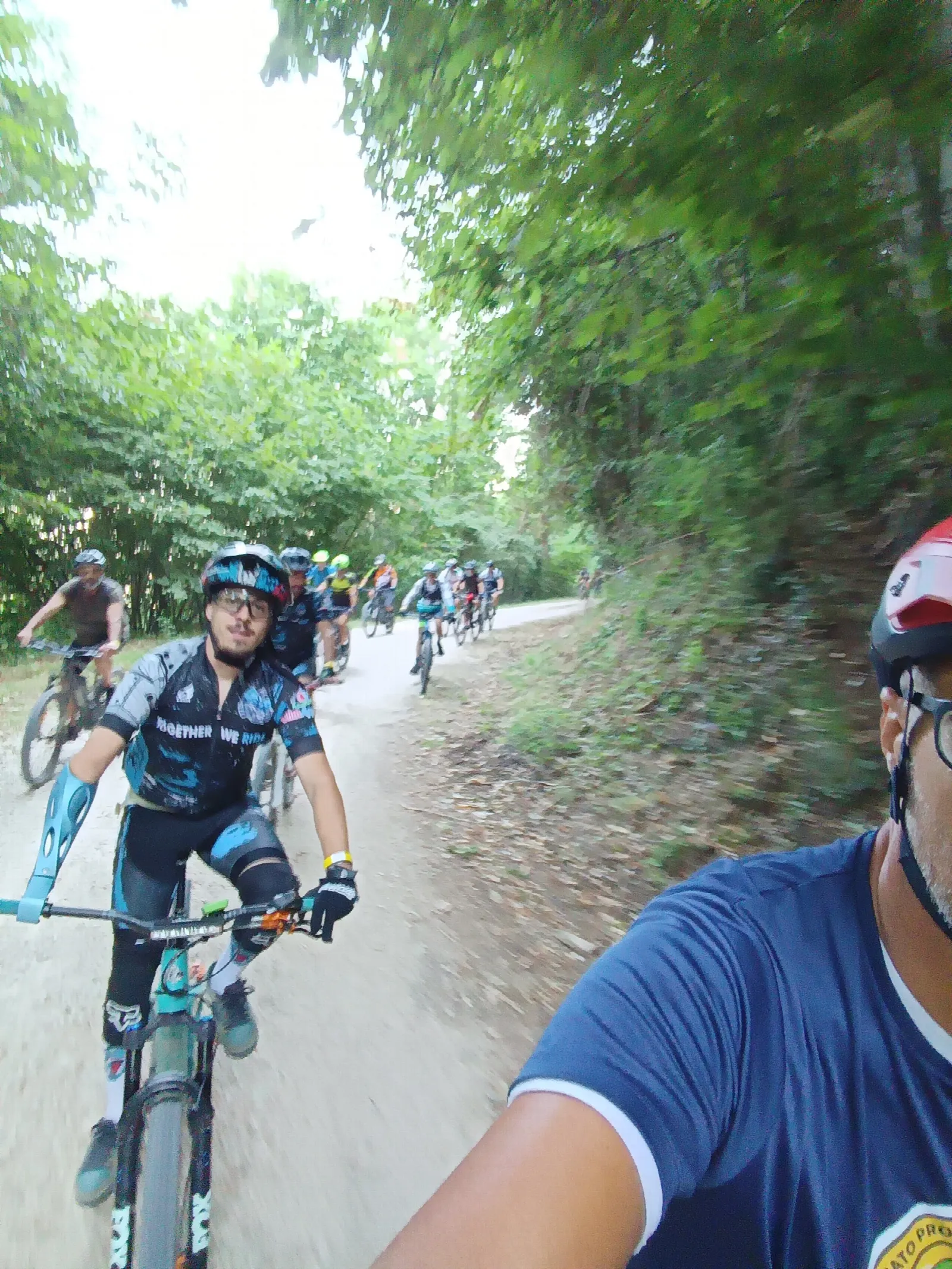 Biker in salita su una strada sterrata nel bosco durante «Sentieri al tramonto»