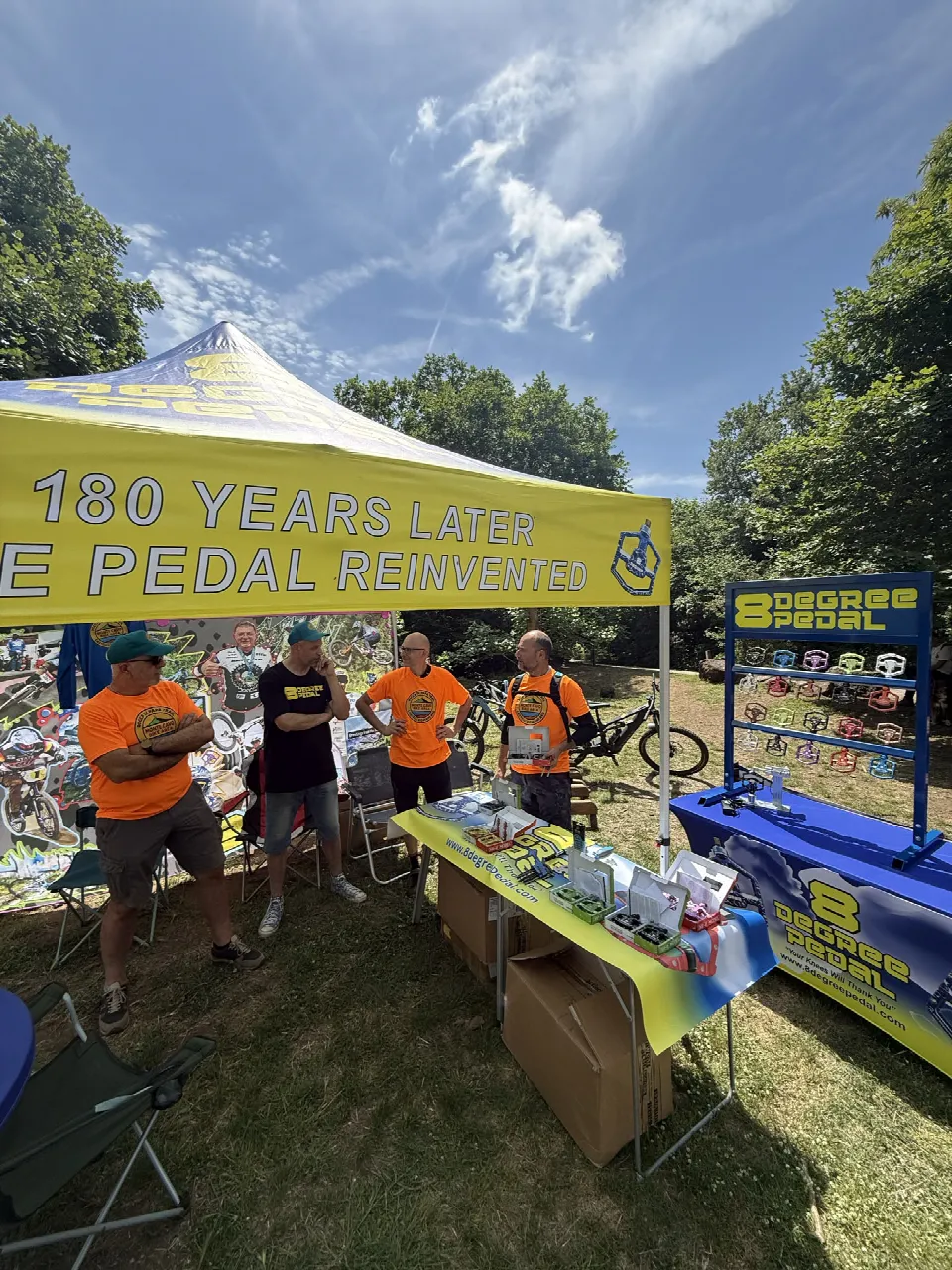 Lo stand di 8 Degree Pedal con il gazebo giallo e i visitatori