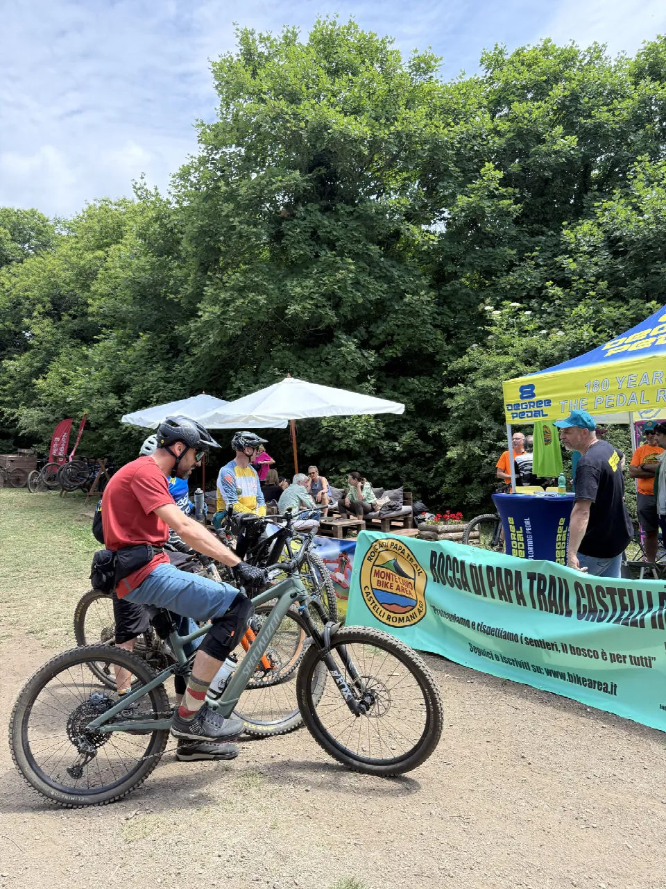 Un biker in sella accanto allo striscione dell'associazione al Test Day