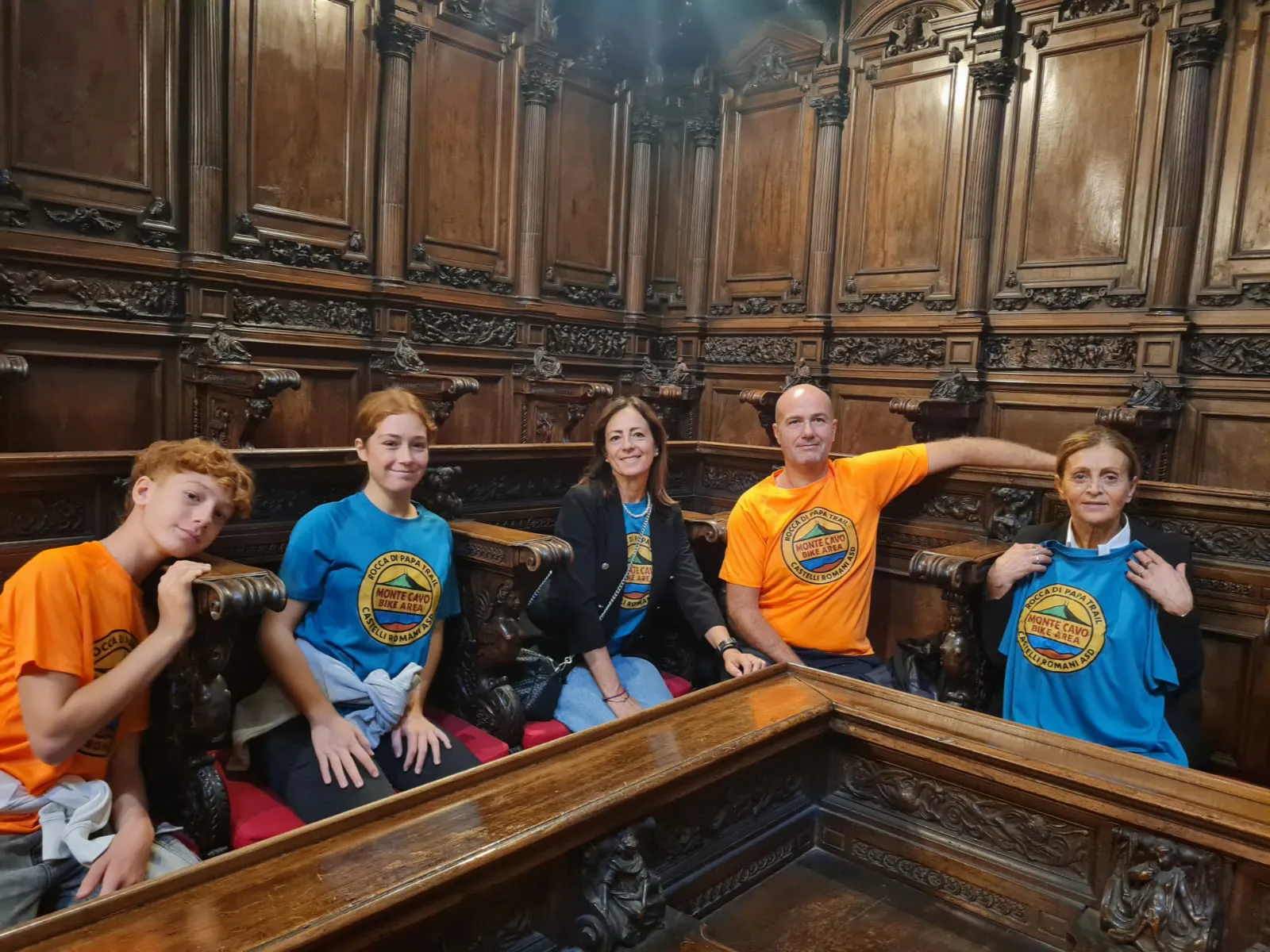 Soci con le maglie dell'ASD nel coro in legno durante la visita in Vaticano